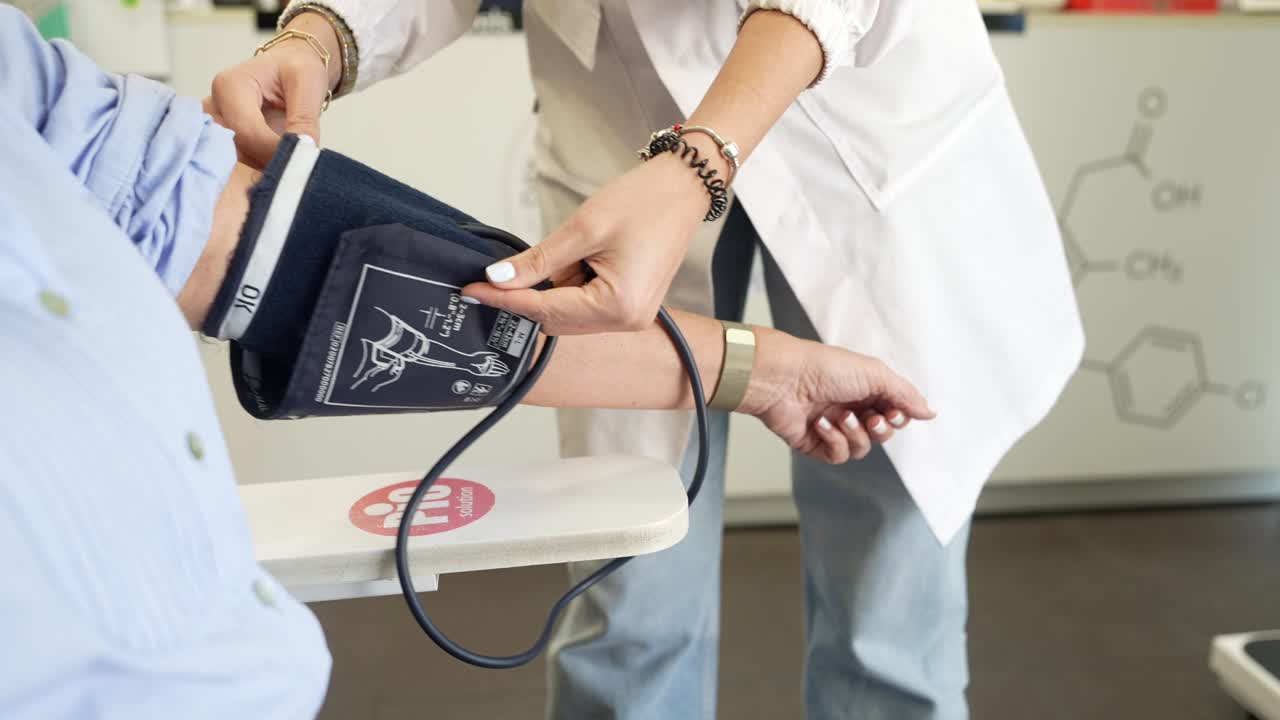 Medical Professional Removing Blood Pressure Cuff from Patient's Arm