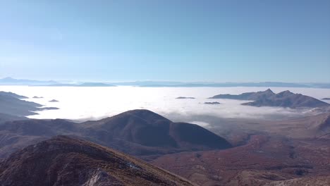 drone shot of landscape and a hiker standing on the mountain peak