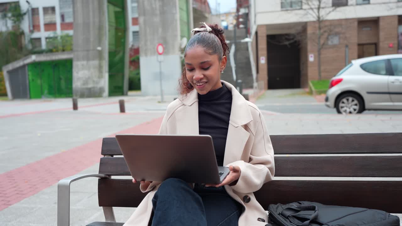 Woman working on laptop in city park