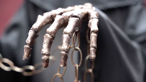 bones of a hand holding a chain