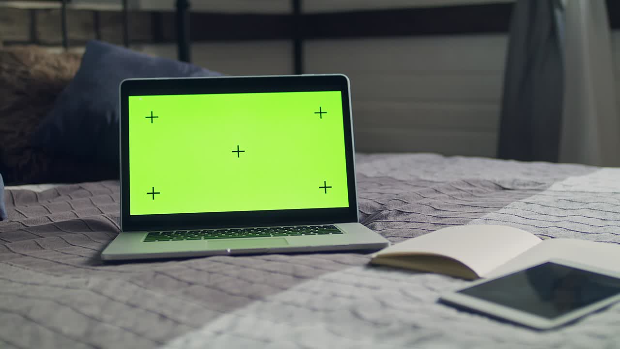 Green screen with tracking markers on the laptop.