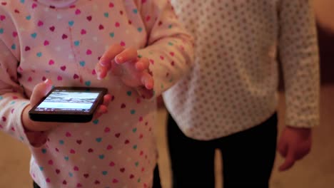 Vista-Frontal-De-Un-Niño-Pequeño-Deslizando-Imágenes-En-Un-Teléfono-Celular