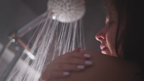 la mujer lava el cuerpo con movimientos suaves de la mano. los movimientos de la mano ayudan a limpiar el cuerpo de la joven dama morena. la mujer limpia el cuerpo con movimiento tierno