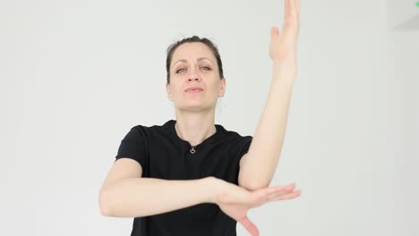 woman demonstrating arm movements against a white background