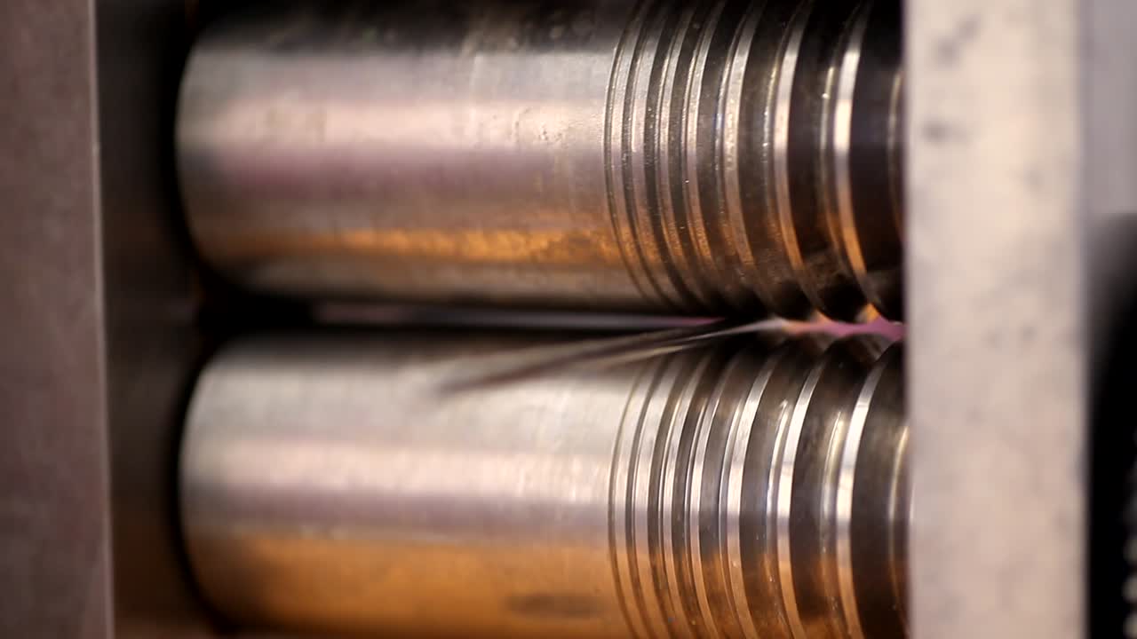 joyero artesano forja rodillos de alambre de plata con rodillo de máquina en el lugar de trabajo en el taller de joyería