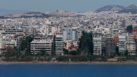 tight aerial slider shot of the sea, athens houses and the acropolis