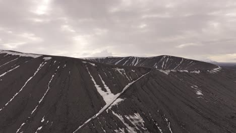 aerial view of hverfjall crater with hikers on snowy ridge trail. hverfjall, mývatn, iceland