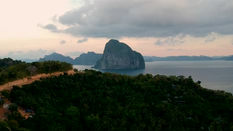 Aerial-of-Pinagbuyutan-Island-at-sunset-from-Las-Cabanas-beach,-El-Nido,-Palawan,-Philippines