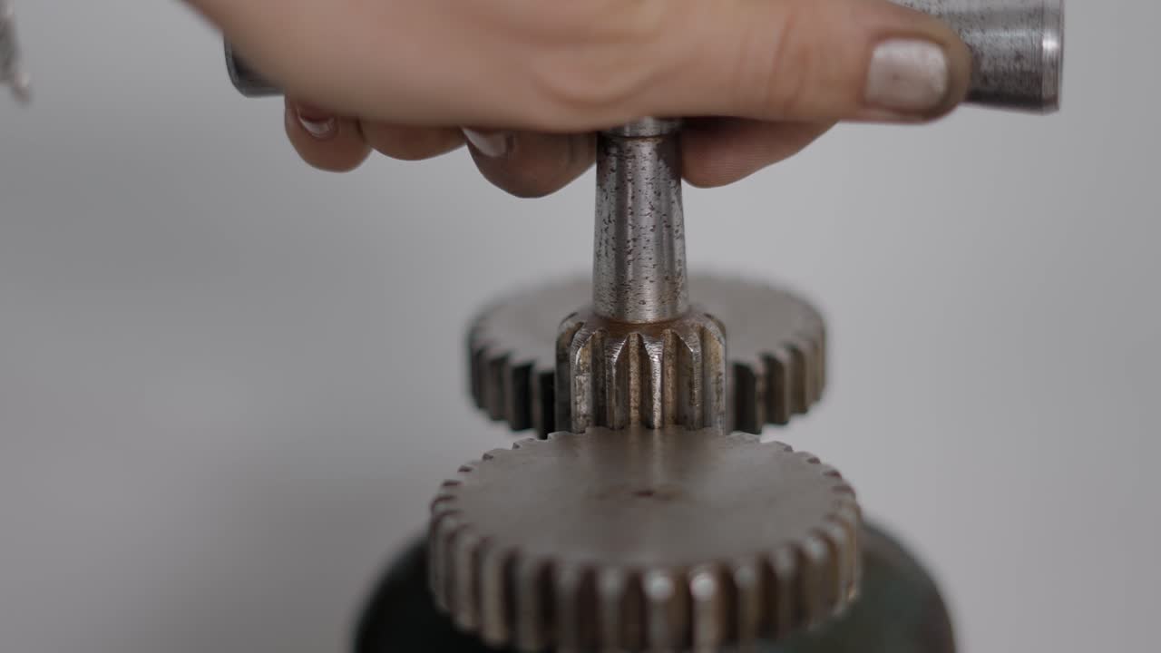 Hand Operating an Antique Machine with Gears