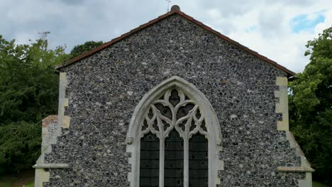 A-rising-boom-shot-of-All-Saints-church-in-West-Stourmouth,-rising-from-the-window-up-to-see-the-steeple