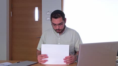 middle eastern jewish professional holding a blank white sheet of paper