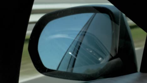 espejo retrovisor del coche mientras conduce por la carretera