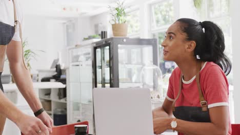 Happy-diverse-male-and-female-baristas-talking-and-having-coffee-in-their-cafe