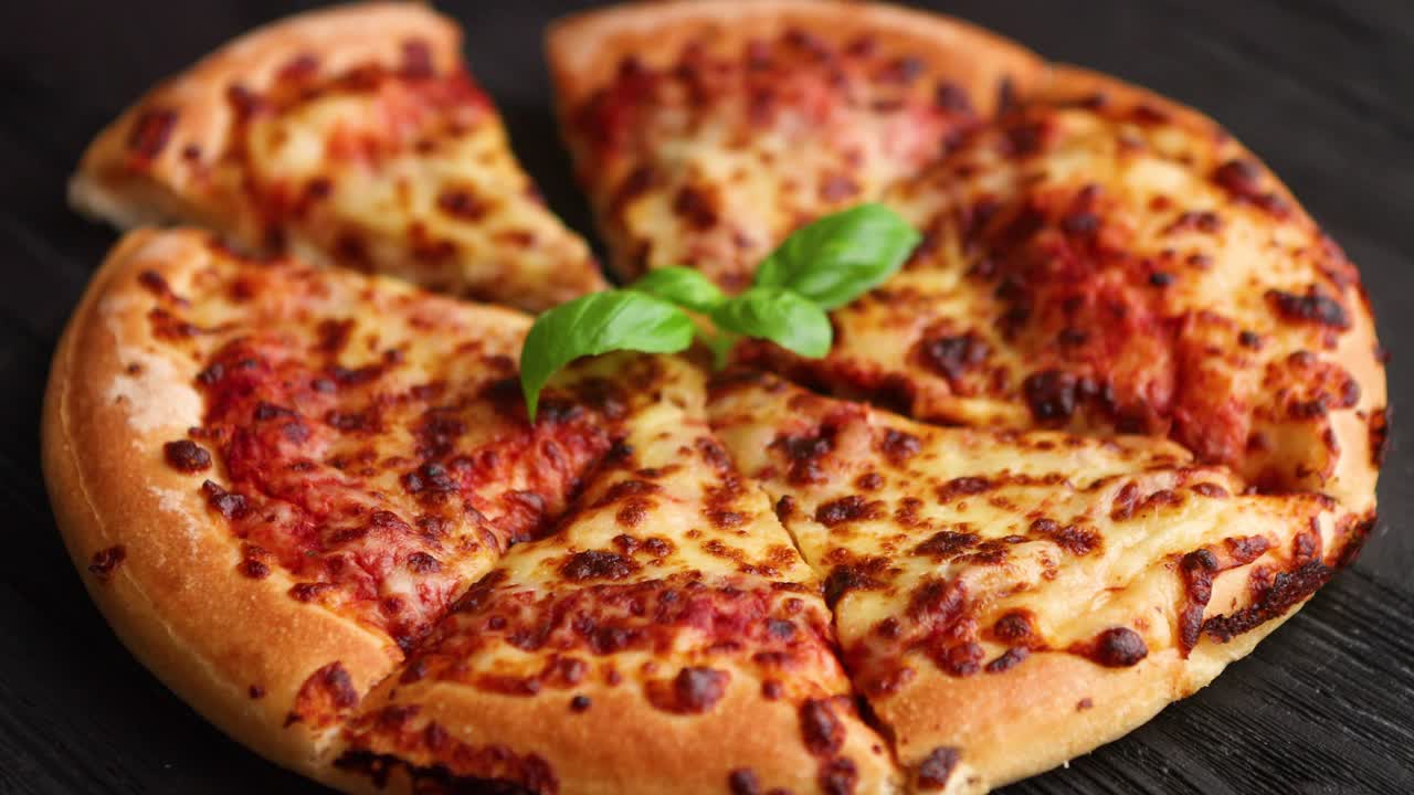 Sliced pizza Margarita with basil leafs