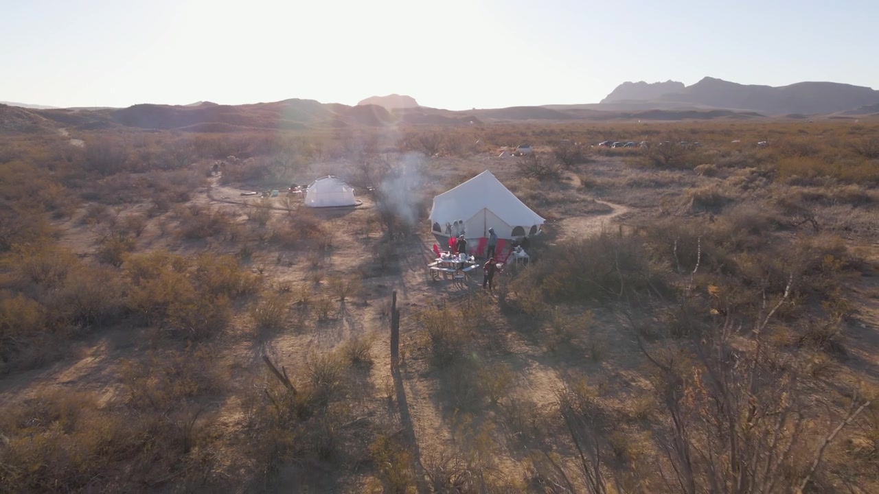 Luftpanorama drone zoom ud over glampingtelte og campingplads i Big Bend National Park, tørt ørkenlandskab med bjerge og kløfter, Sydtexas