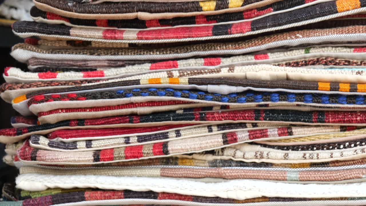 Stacked Pile of Colorful Rugs and Carpets