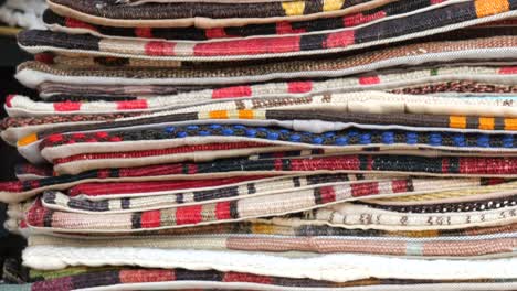 stacked pile of colorful rugs and carpets