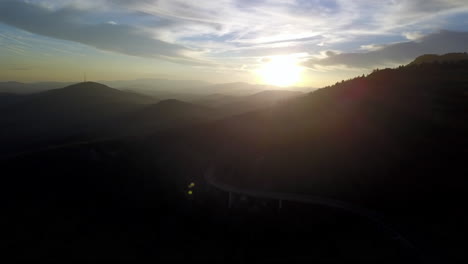 aerial view of mount mitchell in the background with the linn cove viaduct along the blue ridge parkway in the foreground