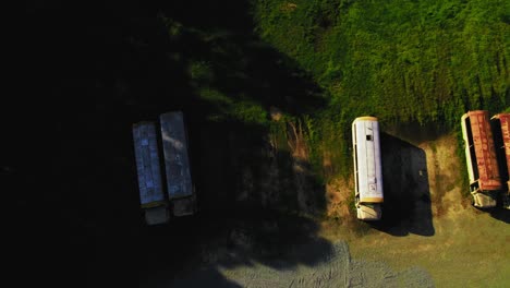 aerial view of abandoned american old school buses in overgrown storage lot