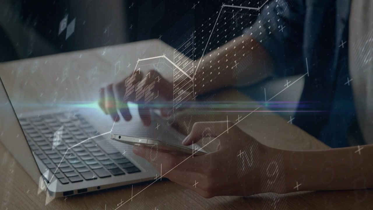 Male IT right-thumb tapping phone while left typing on laptop HUD charts overlaying hands for data