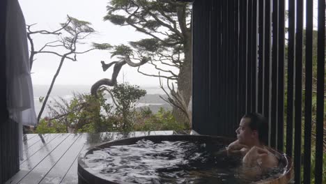 man in vacation relaxing in a hot tub at the hotel on a cold rainy day