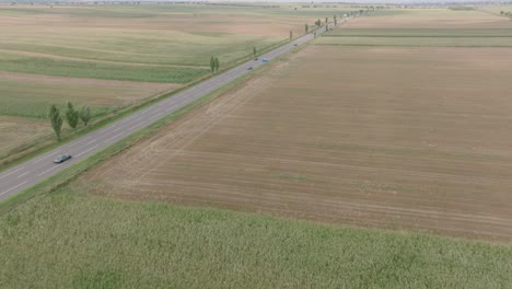 Vehicles-Driving-On-European-Route-85-Through-Fields-In-Romania