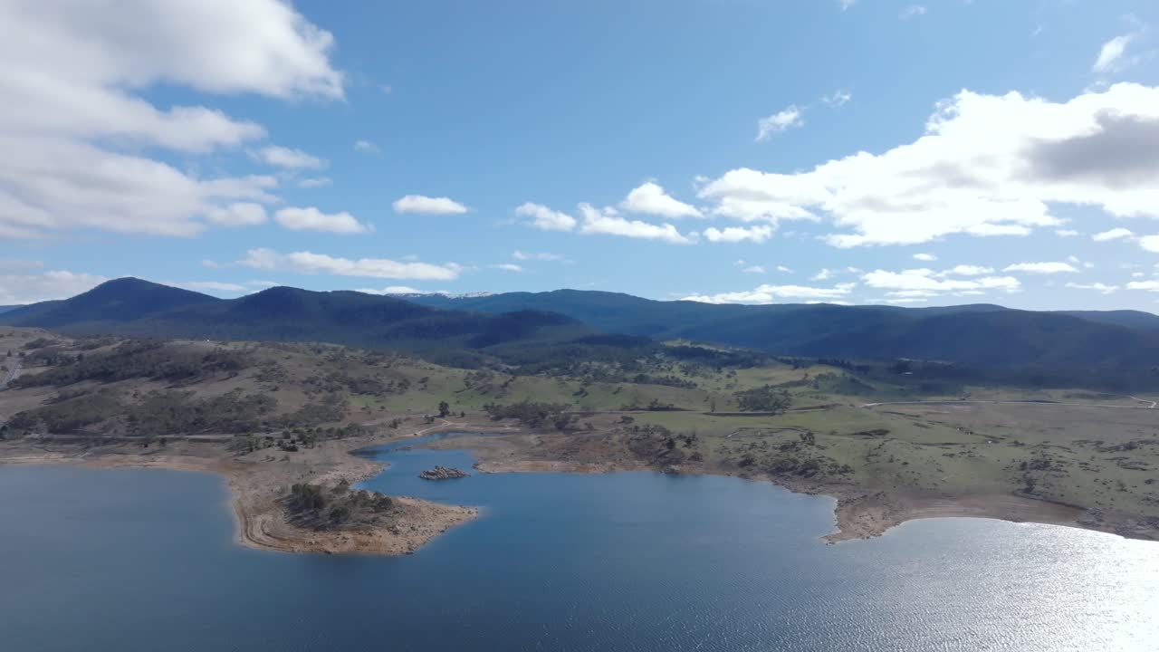 Big wide drone shot over Lake Jindabyne looking towards the Snowy Mountains and kosciuszko national park, Australia