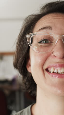 vertical video of portrait of happy caucasian female worker in workshop in slow motion