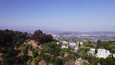 Luftbild-Panorama,-Das-Die-Riesige-Stadtlandschaft-Von-Los-Angeles-Von-Den-Hügeln-Aus-Zeigt-Und-Die-Zersiedelung-Vor-Der-Kulisse-Der-Berge-Hervorhebt