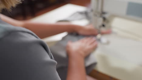 weaver places fabric under weaving machine, adjusting properly with hands, ensuring accurate alignment, focusing on craft, guiding material for secure stitching, reflecting skillful handling