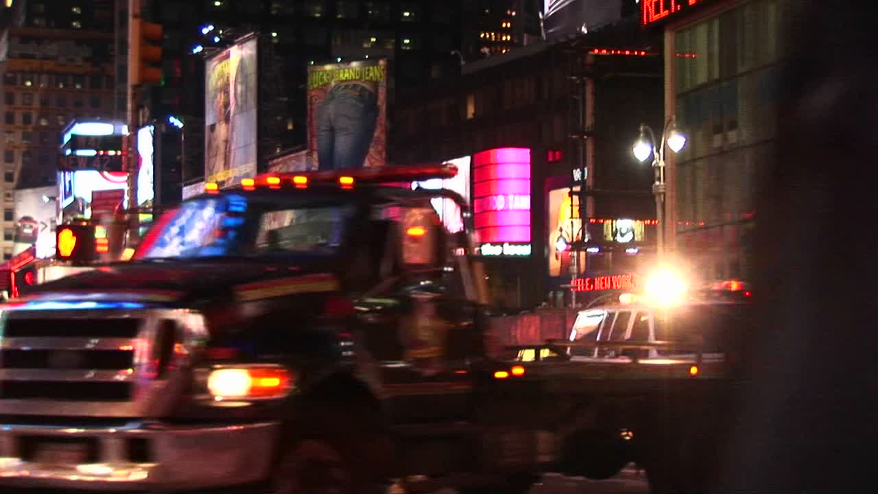 보행자와 회전하는 차량이 있는 타임 스퀘어의 미디엄샷