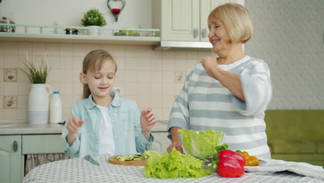 grandmother and granddaughter making salad together