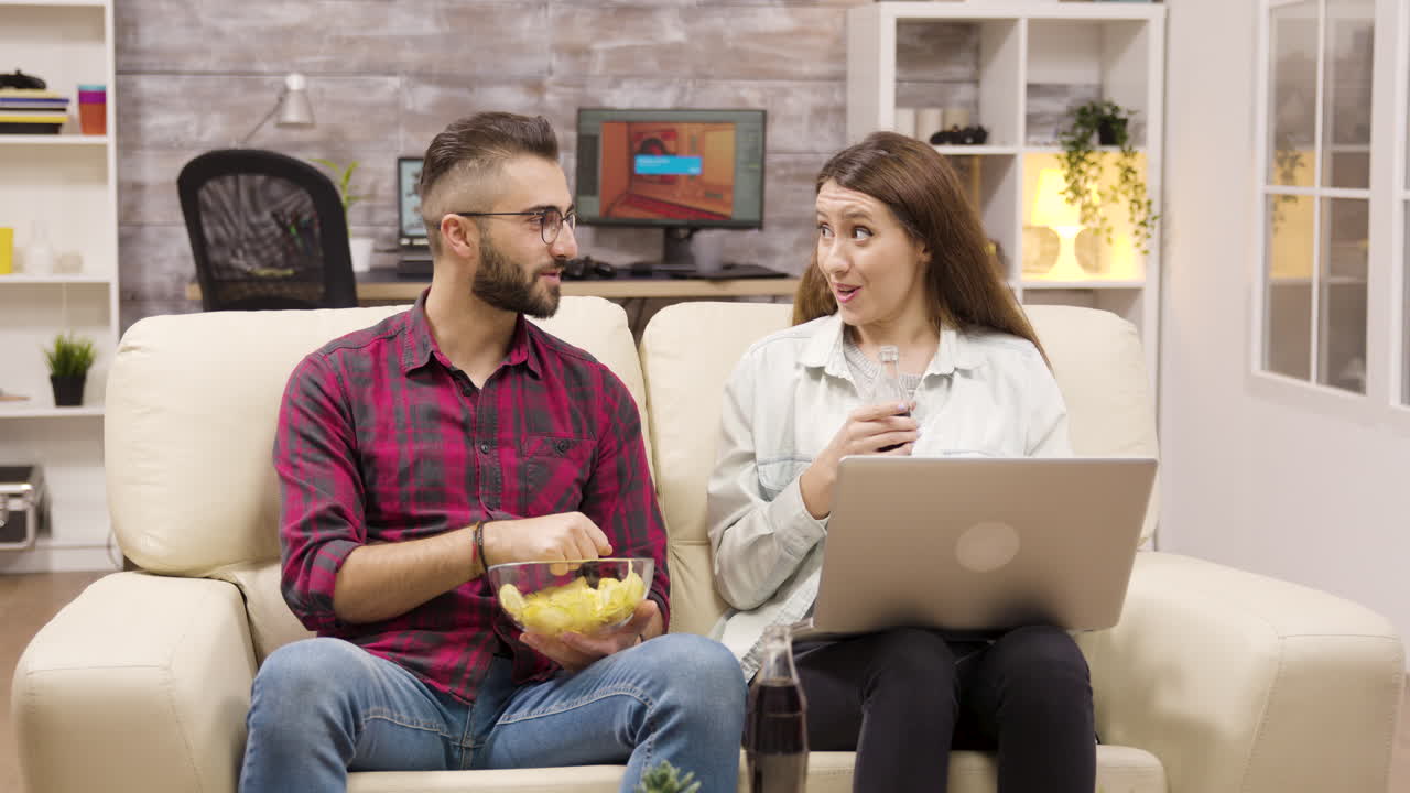 Couple Relaxing at Home Watching a Movie and Eating Chips