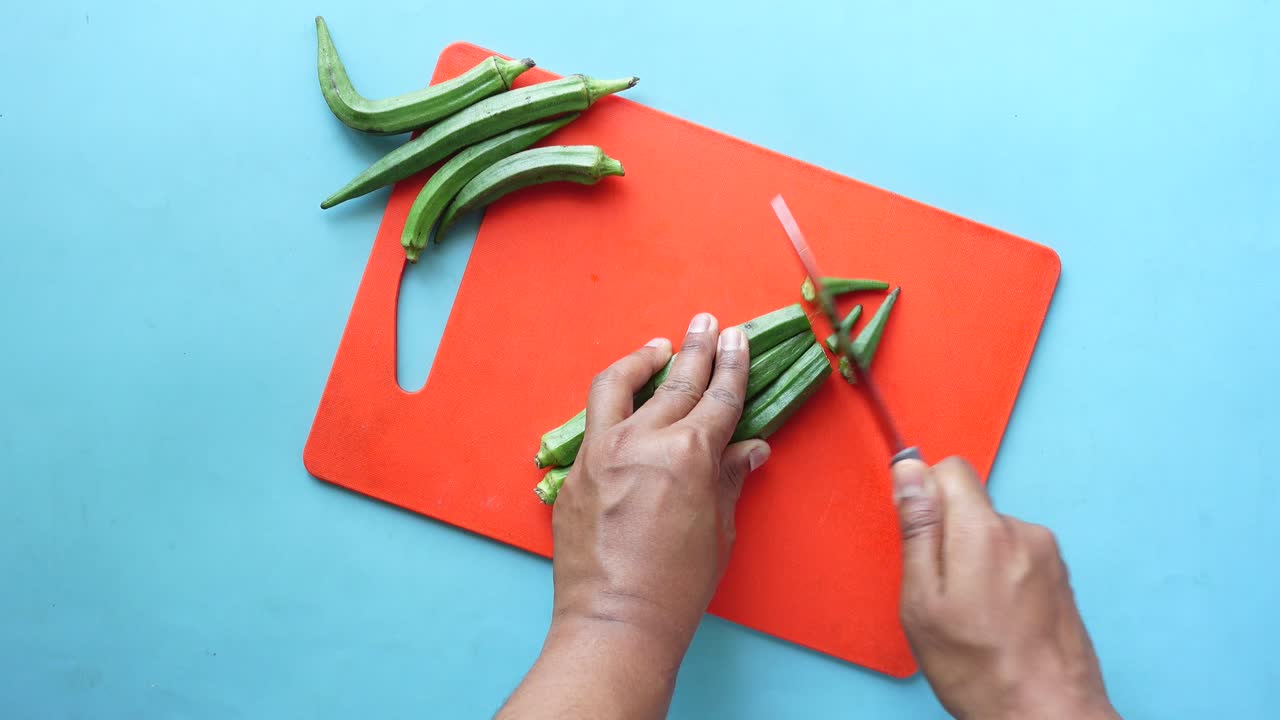 절단판 에 오크라 를 잘라내는 손 들 의 가까운 모습