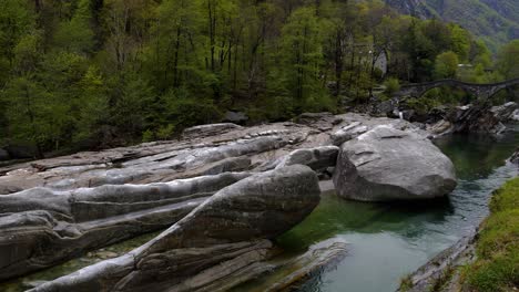 Pan-up-green-stream-to-ponte-dei-salti-bridge-with-stunning-vibrant-foliage