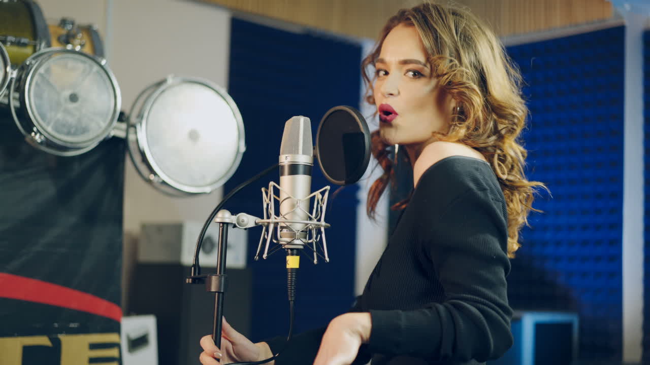 Woman singing in a recording studio. Female vocals. Professional recording studio.