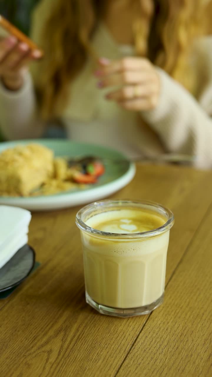 Donna che fa colazione o pranza in un bar