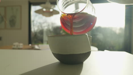 pouring rich coffee into ceramic mug in sunlit room