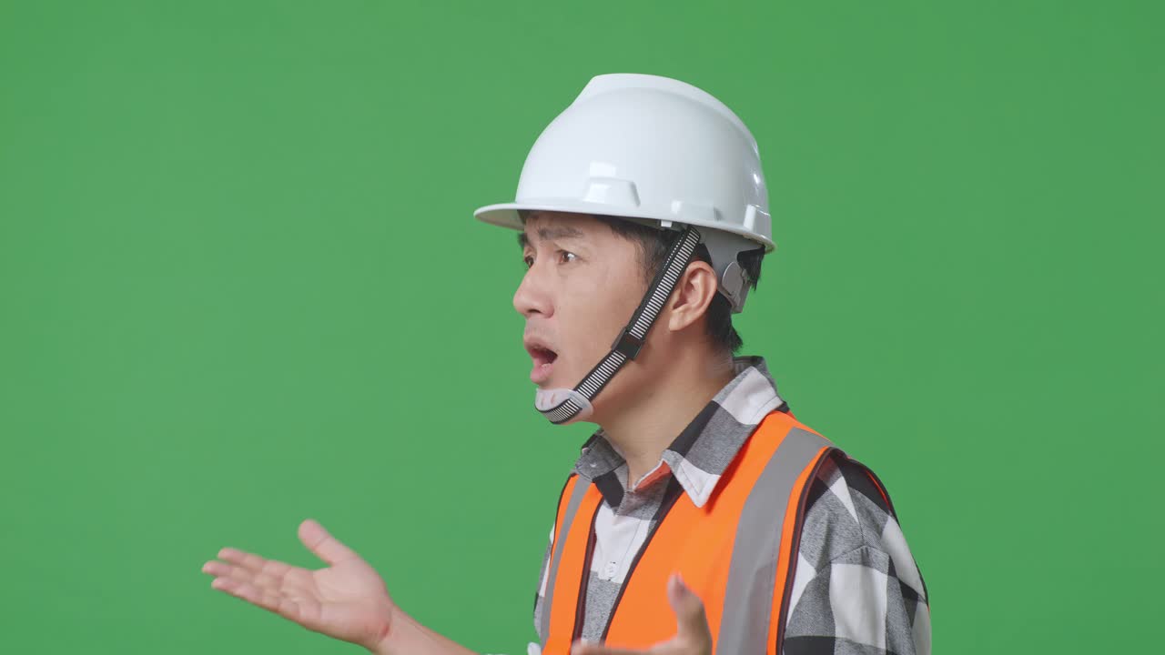 Close Up Side View Of Ondering Asian Male Engineer With Safety Helmet Saying Why Working Doubtfully In The Green Screen Background Studio