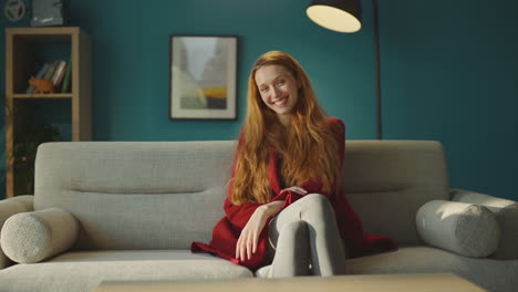 happy woman sitting on couch at home