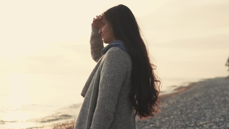 Donna sulla spiaggia al tramonto