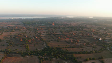 Drone-dolley-shot-over-the-landscape-of-Myanmar-with-the-Bagan-Viewing-Tower-in-the-distance