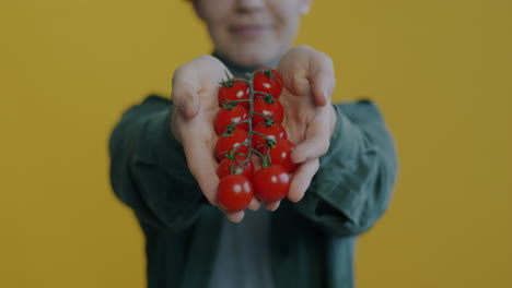 woman holding fresh cherry tomatoes