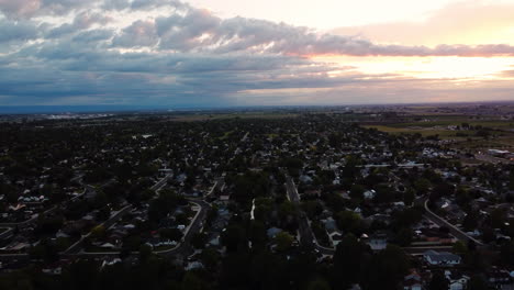 Vista-Aérea-Del-Paisaje-Sobre-Una-Zona-Verde-Suburbana,-Durante-La-Puesta-De-Sol