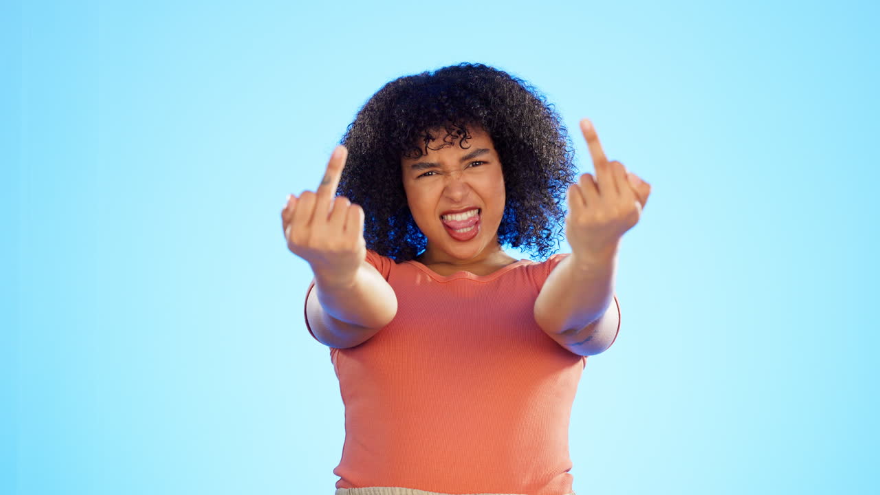 mujer negra, enojada y dedo medio en el estudio