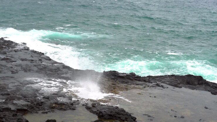 L'acqua schizza attraverso un soffione naturale nelle rocce lungo la costa di Kauai.