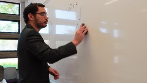 man writing an integral of a cosine function