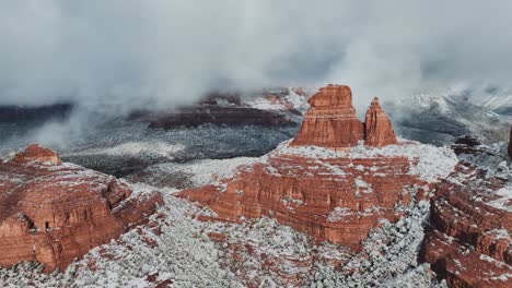 low clouds engulfing snow-capped red rocks in sedona, arizona, united states