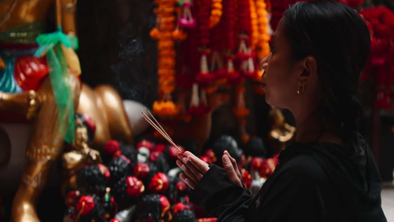 Woman praying with incense in temple