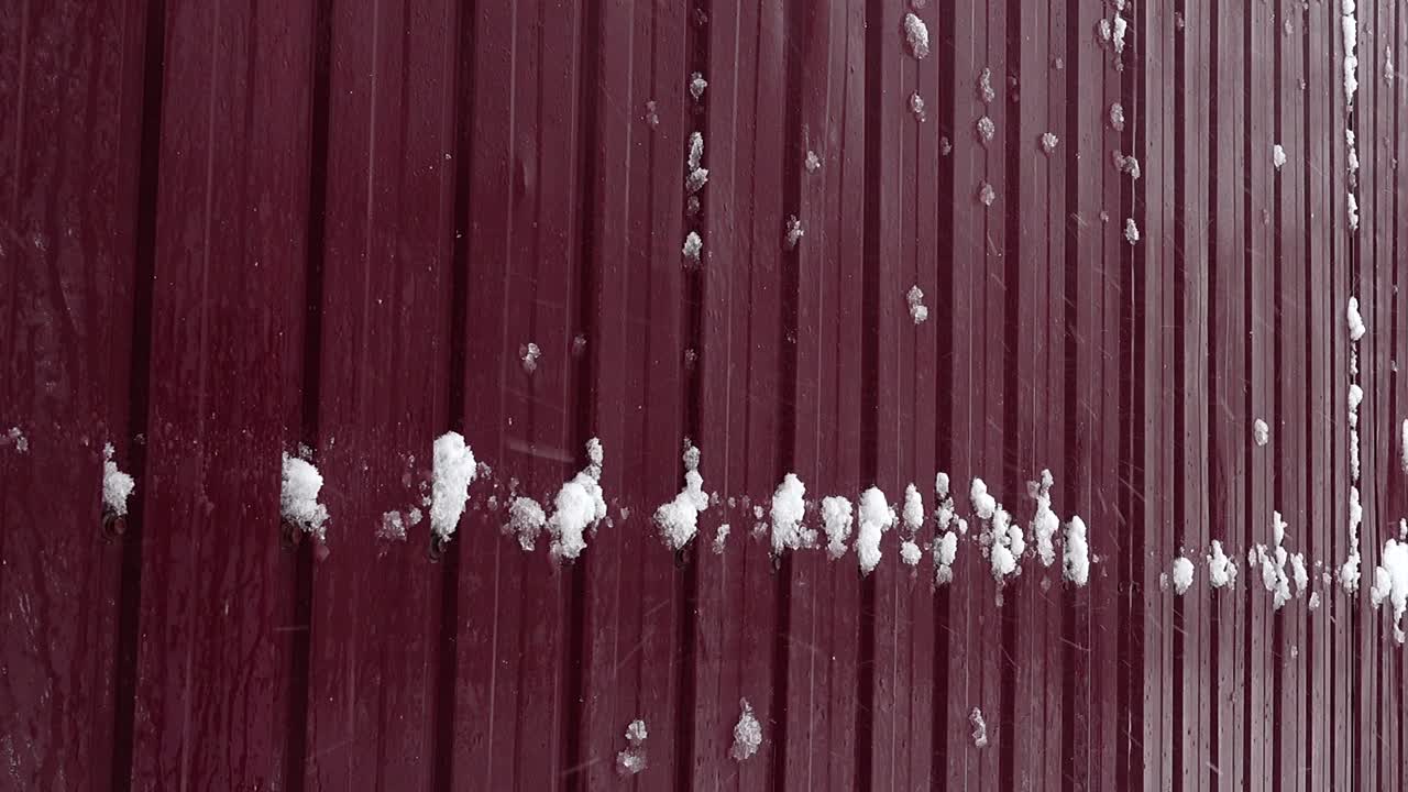 Snow against the background of a fence. Snow in the city. Shooting in the winter